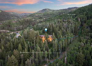 Aerial view at dusk of a mountain view, property parcel outlined, and a wooded view