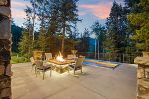 Patio terrace at dusk featuring a patio area and a fire pit