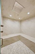 Full bath with a marble finish shower and recessed lighting