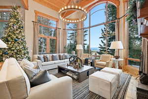 Living room with a chandelier, hardwood / wood-style flooring, wooden ceiling, high vaulted ceiling, and plenty of natural light