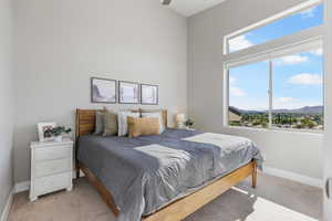 Bedroom with a mountain view and light colored carpet