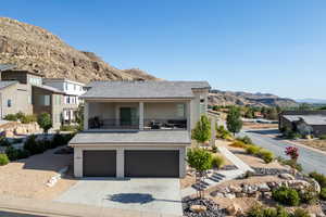 Contemporary home with a balcony, a mountain view, stucco siding, concrete driveway, and an attached garage