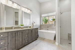 Bathroom featuring a freestanding tub, double vanity, and a stall shower