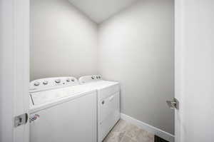 Laundry room featuring washing machine and dryer and vaulted ceiling
