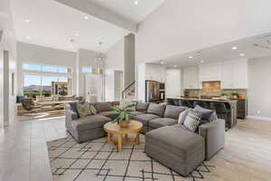 Living room with high vaulted ceiling, recessed lighting, a chandelier, and beam ceiling