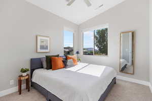 Bedroom featuring vaulted ceiling, light colored carpet, and ceiling fan