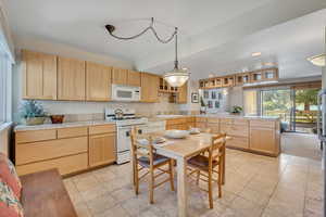 Kitchen with light brown cabinets, white appliances, a peninsula, recessed lighting, and tile countertops