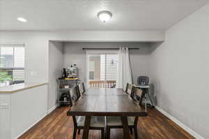 Dining room featuring dark wood finished floors and a textured ceiling