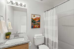 Bathroom with shower / bath combination with curtain and vanity