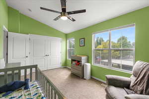Carpeted bedroom featuring vaulted ceiling, a closet, and ceiling fan