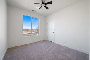 Unfurnished room with a mountain view, carpet floors, and a ceiling fan