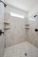 Full bathroom featuring a tile shower and plenty of natural light