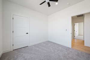 Empty room featuring light carpet and a ceiling fan