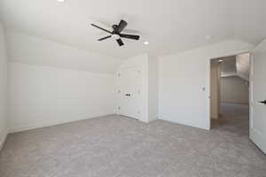 Additional living space with vaulted ceiling, light colored carpet, recessed lighting, and ceiling fan