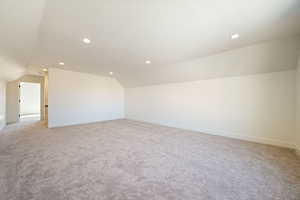 Additional living space featuring lofted ceiling, light colored carpet, and recessed lighting