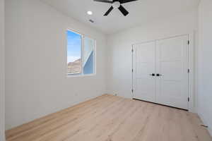 Unfurnished bedroom featuring light wood-style flooring, ceiling fan, a closet, and recessed lighting