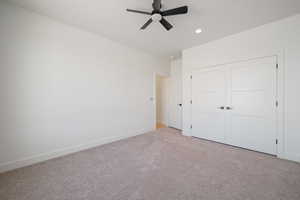 Unfurnished bedroom featuring carpet floors, a closet, ceiling fan, and recessed lighting
