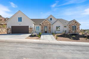 View of front of house featuring stone siding, concrete driveway, a shingled roof, stucco siding, and a garage