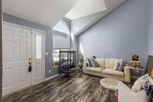 Entrance foyer with dark wood finished floors and high vaulted ceiling