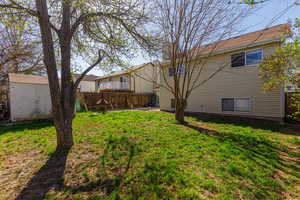 Fenced backyard featuring a patio area and a storage unit