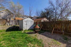 Fenced backyard with a shed and a residential view