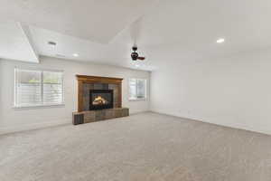 Unfurnished living room featuring light colored carpet, recessed lighting, a fireplace, and ceiling fan