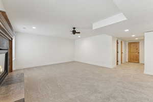 Living Room featuring recessed lighting, light colored carpet, a glass covered fireplace, and a ceiling fan