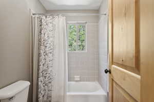 Bathroom featuring shower / bath combo and toilet