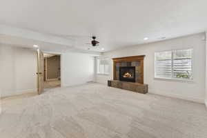 Unfurnished living room featuring light carpet, a tiled fireplace, recessed lighting, and ceiling fan