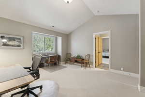 Carpeted office space with lofted ceiling and baseboards