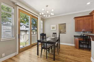 Dining room featuring crown molding, light wood-style floors, and a chandelier