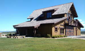 Rear view of property featuring a yard, board and batten siding, and asphalt driveway