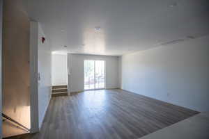 Unfurnished living room with dark wood finished floors and a textured ceiling