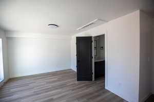 Unfurnished room featuring wood finished floors and a textured ceiling
