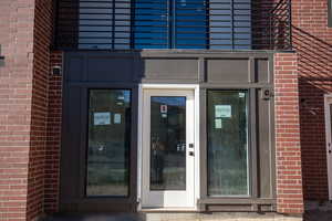 Doorway to property featuring brick siding