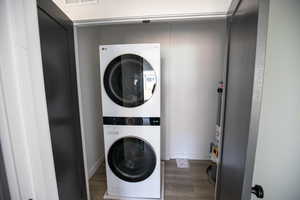 Laundry room featuring wood finished floors and estacked washer and dryer