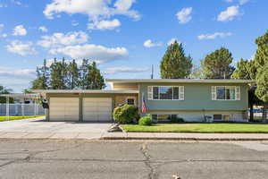 View of front of property featuring concrete driveway and a garage