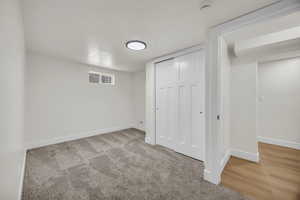 Unfurnished bedroom with a closet and light carpet