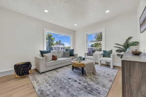 Living area with light wood finished floors, recessed lighting, and a textured ceiling