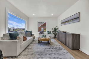 Living area featuring light wood-type flooring, a textured ceiling, and recessed lighting
