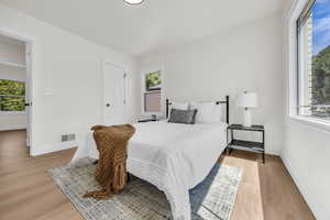 Bedroom featuring multiple windows and light wood-style floors
