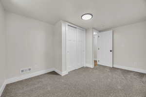 Unfurnished bedroom featuring carpet and a closet