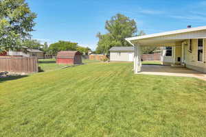 Fenced backyard with a covered patio area.