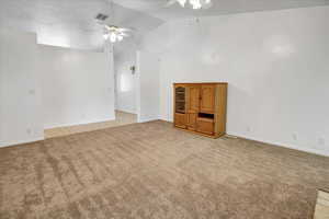 Family room with vaulted ceiling, light carpet, and ceiling fan