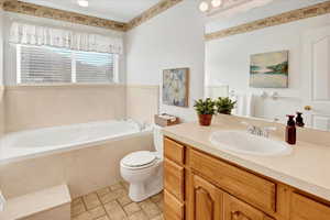 Bathroom featuring vanity, a garden tub, and light tile patterned floors