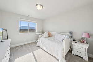 Bedroom featuring light colored carpet and a mountain view