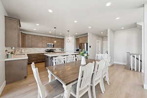 Dining area with light LVP flooring and recessed lighting