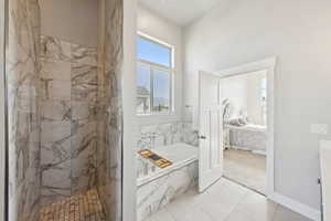 Ensuite bathroom featuring a garden tub, a marble finish shower, and tile patterned flooring