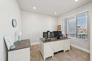 Home office with light carpet and recessed lighting