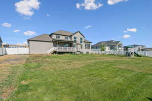 Rear view of house featuring a fenced backyard, oversized deck and automatic sprinklers